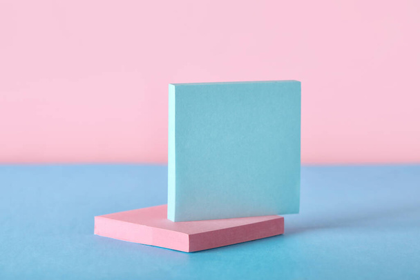 Note adesive sul tavolo blu vicino alla parete rosa - Foto, immagini