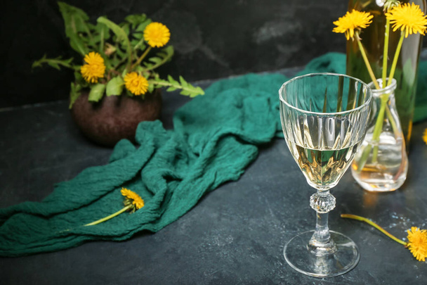 Szklanka wina mniszka lekarskiego na ciemnym stole - Zdjęcie, obraz