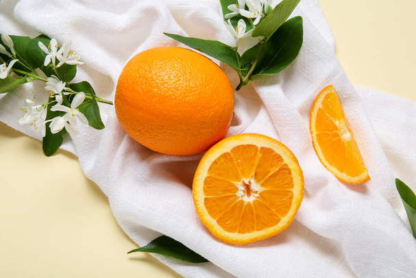 Апельсины с цветущими ветвями на бежевом фоне - Фото, изображение