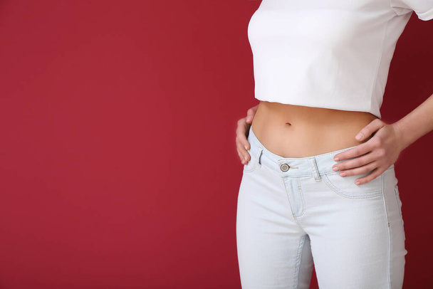 Young slim woman on burgundy background. Diet concept - Photo, Image