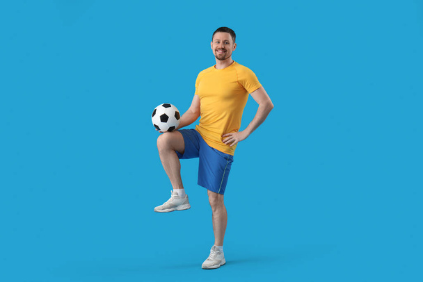Mies pelaa jalkapalloa sinisellä pohjalla - Valokuva, kuva