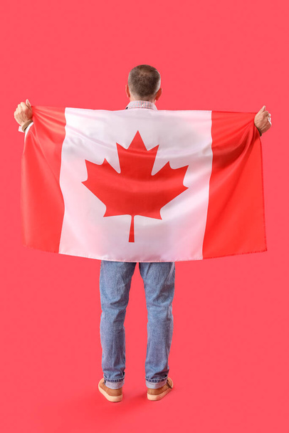 Mature man with flag of Canada on red background, back view - Photo, Image
