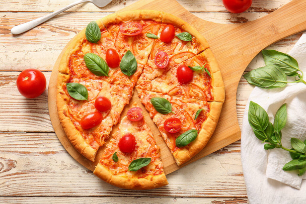 Bord met lekkere pizza margarita op witte houten achtergrond - Foto, afbeelding