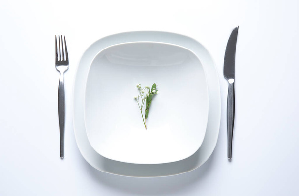 Beautiful table setting and gypsophila flowers on white background - Foto, afbeelding