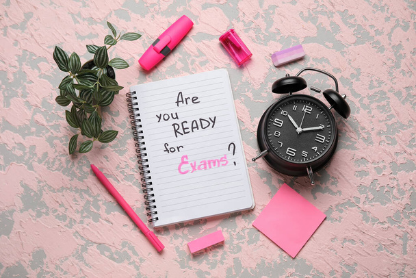 Блокнот з питанням ARE you READY FOR EXAM?, будильник і різні канцелярські товари на гранжевому рожевому фоні
 - Фото, зображення