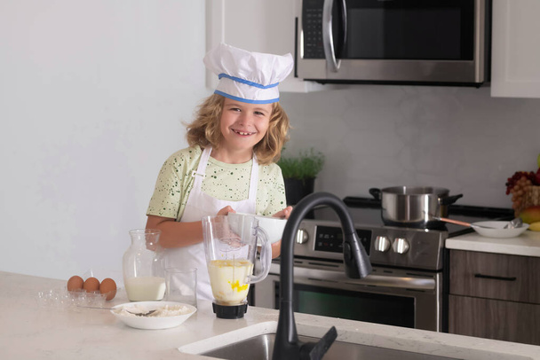 Criança cozinheira. Engraçado criança stand na mesa da cozinha se divertir cozimento, fazendo padaria preparando alimentos em casa kithen. Comida saudável. Pequeno chef preparando refeição saudável - Foto, Imagem