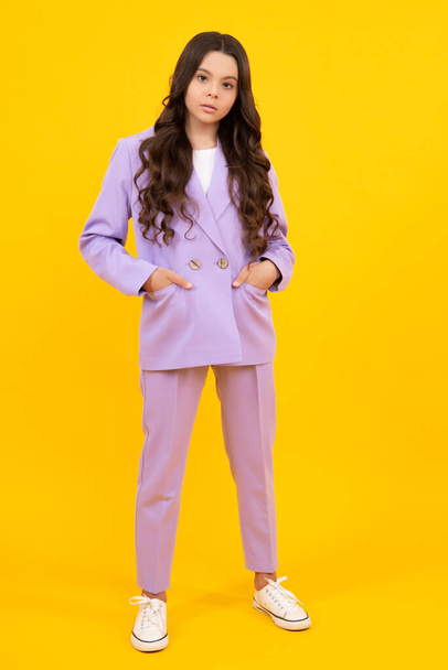 Full length of cheerful teenager child girl wearing comfy trendy fashion clothes, isolated over yellow background - Fotó, kép