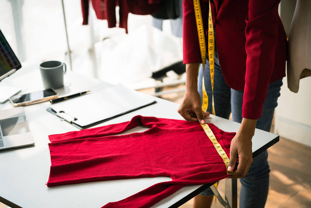 Африканська жінка - дизайнер перевіряє деталі та вимірює нову колекцію светрів.. - Фото, зображення