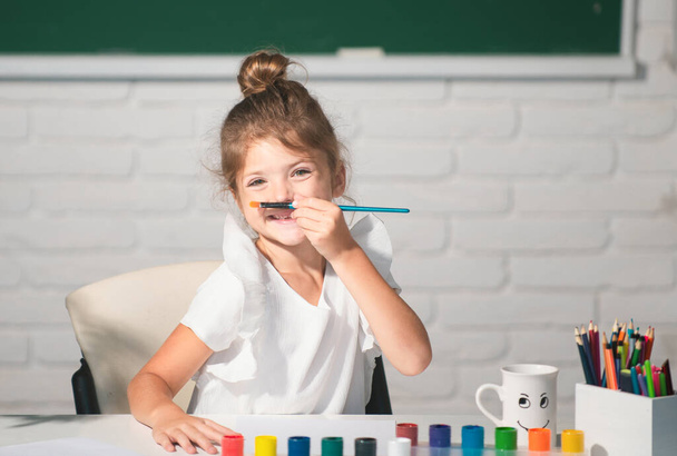 Child girl drawing with coloring pens paintind. Portrait of adorable little girl smiling happily while enjoying art and craft lesson in school. Kids creative education concept. - Fotografie, Obrázek
