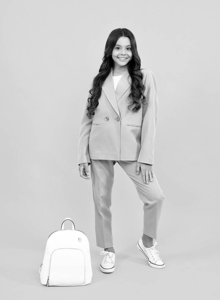 School teen girl in with backpack. Teenager student on isolated background. Kids learning, education, studying and knowledge. Happy face, positive and smiling emotions of teenager schoolgirl - Foto, Imagen