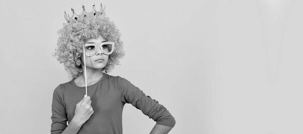 serious teen girl in fancy clown wig wear queen crown and funny party glasses, arrogant. Funny teenager child in wig, party poster. Banner header, copy space - Valokuva, kuva