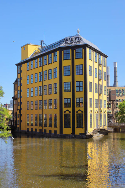 Norrkoping, Sweden - May 18, 2023: The Museum of Work in the yellow building a former weaving mill in the Motala river in the old industrial area. - Foto, Bild