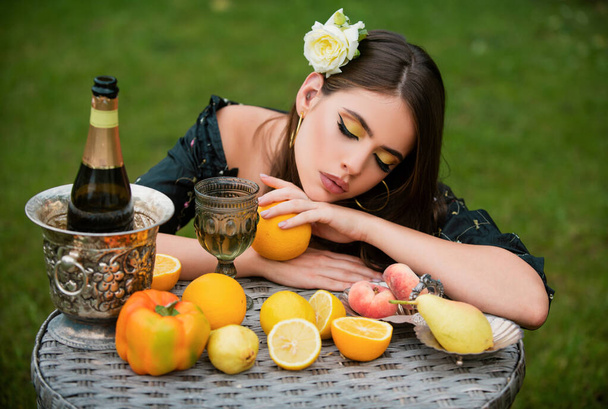 Portrait of sexy woman relaxing and eating fruit outdoor. Exotic summer diet, tropical fruits. Beauty woman face - Fotó, kép