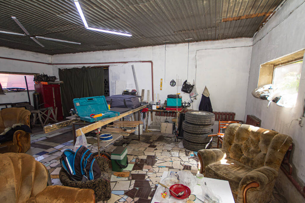 Gran desorden en un garaje suburbano sobre relleno
 - Foto, imagen