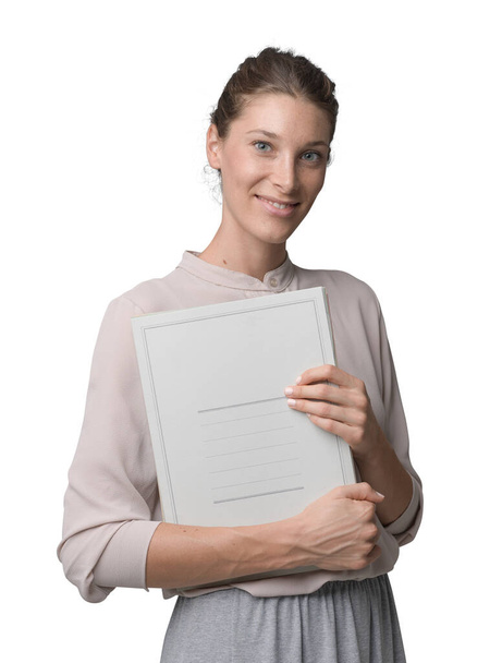 Professional female businesswoman holding paperwork and smiling at camera - 写真・画像
