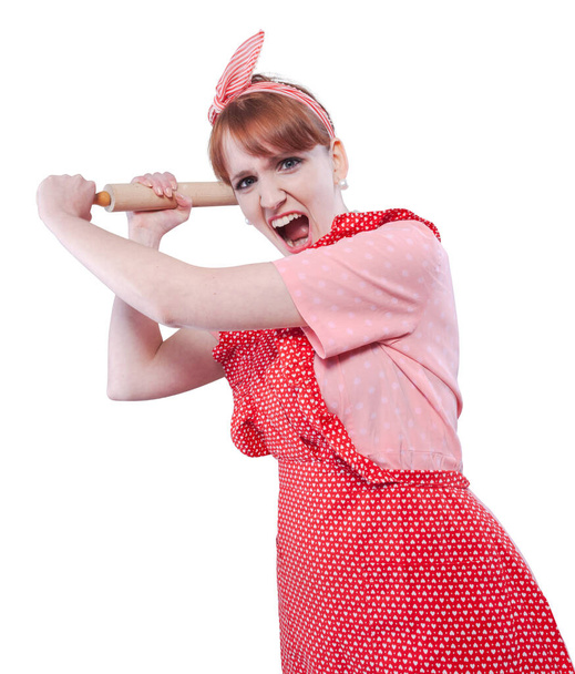 Aggressive vintage style housewife beating someone with a rolling pin and shouting - Photo, image