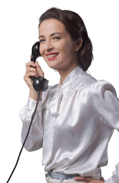 Ελκυστική κομψό vintage Γραμματέας έχοντας ένα τηλεφώνημα και χαμογελαστός - Φωτογραφία, εικόνα