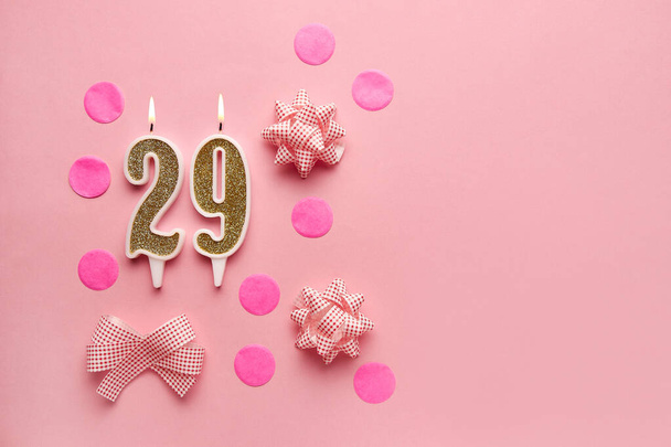 Номер 29 на пастельно-розовом фоне с праздничным декором. С днем рождения свечи. Концепция празднования дня рождения, юбилея, важной даты, праздника. Принято. Баннер - Фото, изображение