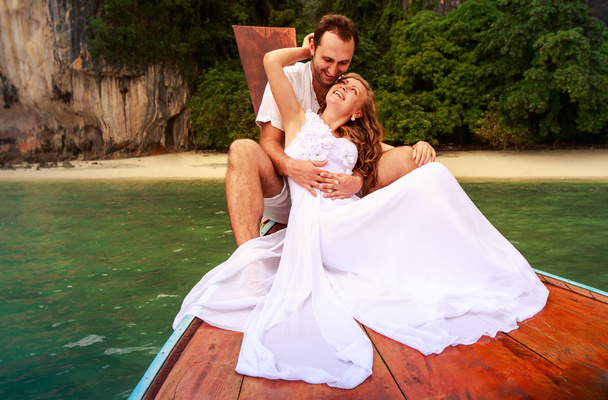groom embrace bride sitting on longtail boat - Photo, Image