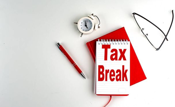 TAX BREAK κείμενο σε ένα σημειωματάριο, κόκκινο στυλό και σημειωματάριο, επιχειρηματική ιδέα, λευκό φόντο - Φωτογραφία, εικόνα