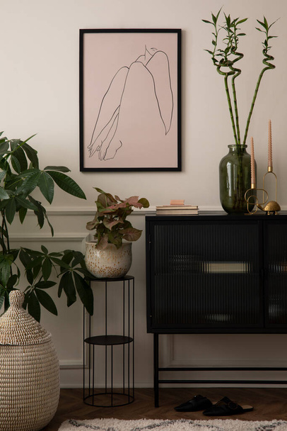 Creative composition of living room interior with mock up poster frame, black sideboard, glass vase with leaves, plants in flowerpots, round stand and personal accessories. Home decor. Template.  - 写真・画像