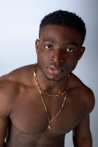 Shirtless african american man with golden necklaces looking at camera and standing isolated on grey, confident and modern pose, fashion shoot - Photo, Image