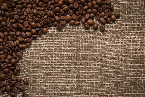 rozptýlené kávová zrna na pytlovina pozadí - Fotografie, Obrázek