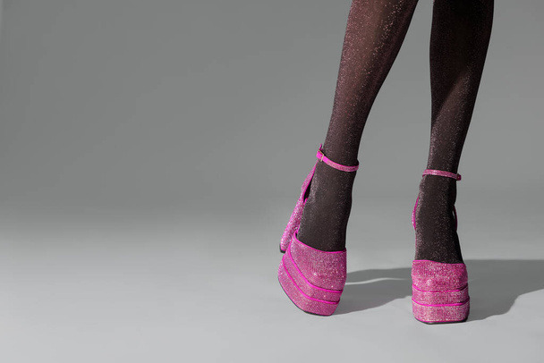 Woman wearing pink high heeled shoes with platform and square toes on light grey background, closeup. Space for text - Fotó, kép