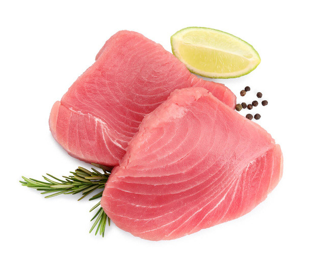 Fresh raw tuna fillets with peppercorns and lime wedge on white background, top view - Zdjęcie, obraz