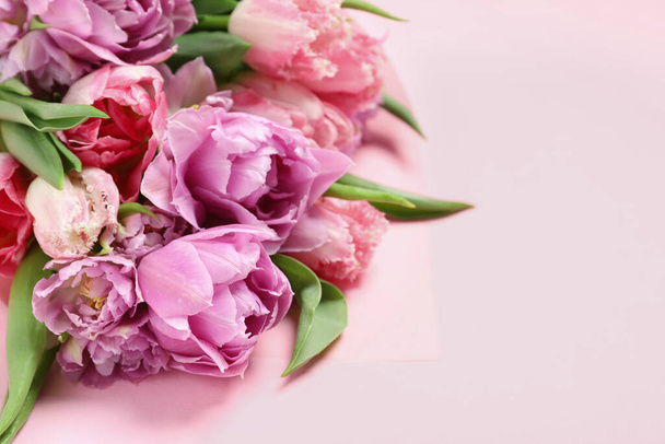 Beautiful bouquet of colorful tulip flowers on pink background - Fotó, kép