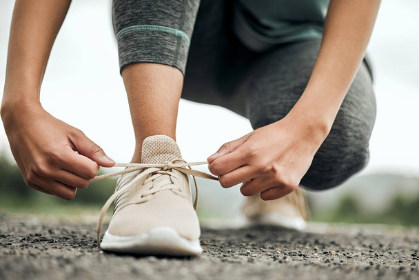Ayakkabılar, koşu ve spor yapan bir kadın dayanıklılık ve kardiyo için spor yaparken bağcıklarını bağlıyor. Egzersiz, sağlık ve antrenman ayakkabılarını bağlayan bir bayan sporcuyla koşuya hazırlanıyor.. - Fotoğraf, Görsel