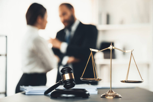 Balanced scale of justice and gavel hammer in focus on blurred background of lawyer colleagues discuss and plan for lawsuit in law firm office, as legal representatives. Equilibrio - Foto, Imagen