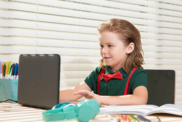 School boy pupil is studying online. Home schooling. Kids distance learning. Cute child using laptop. Education, online study, home studying, homework, schoolboy concept - 写真・画像