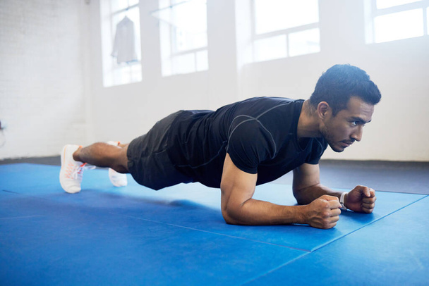 Sports, plank and fitness with man in gym for strong, workout and muscle. Exercise, power and health with male athlete and training on floor for wellness, abdominal challenge and balance. - Photo, Image