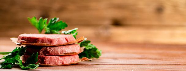 Fresh raw burger on the table. On a wooden background. High quality photo - Foto, afbeelding