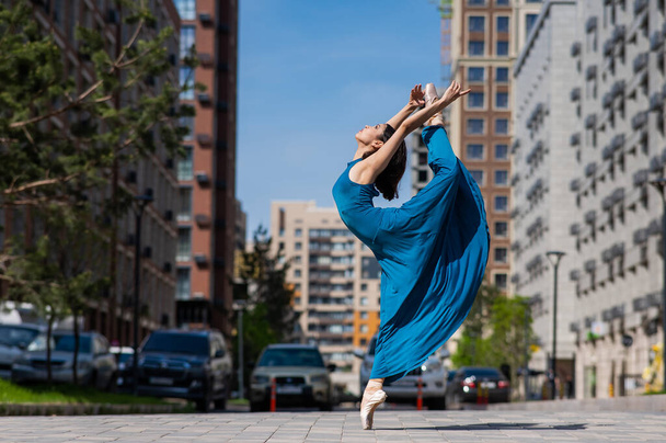 Beautiful Asian ballerina dancing outdoors. Urban landscape - Foto, Bild