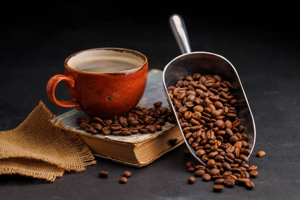 Rijke koffie in een kopje met aromatische geroosterde bonen, een perfecte ochtend brouwsel - Foto, afbeelding