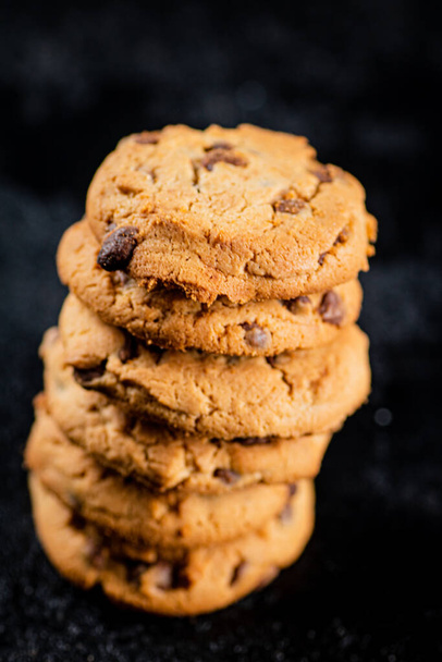 A pile of milk chocolate cookies. On a black background. High quality photo - Foto, imagen