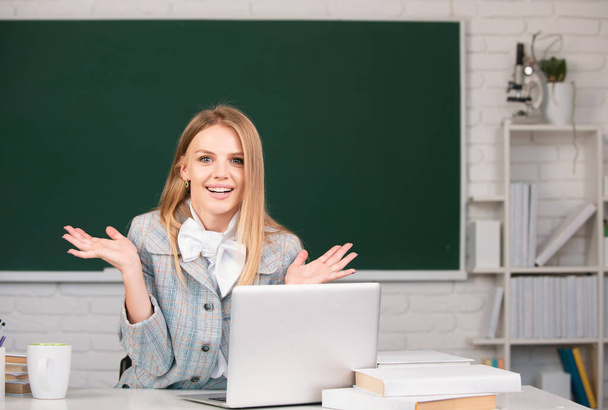 Portrait of young female college student studying in classroom on class on blackboard background - Foto, afbeelding
