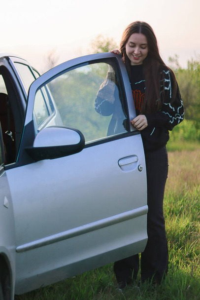 buying a new car.car rental.Girl car enthusiast.Driving school.Girl driver.Woman standing near cars.Beautiful happy woman.Women's rights.Emotions of happiness.Traveling by car.Self-sufficient girl.feminist.Woman car enthusiast.happy woman.laughing - Foto, imagen