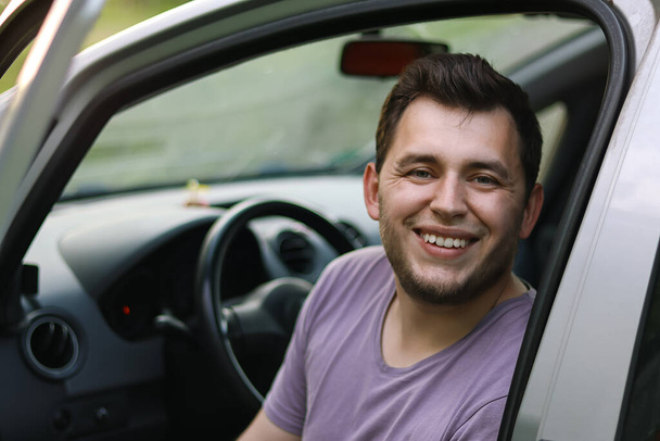 Man driving.First car.Driving school.Renting a car.Happy young man sitting in the auto.Happy moment.Traveling by car.Man smiling.boy with beard.he sits in the car.Brutal man.Ukrainian.Emotion.happy.handsome young man laughing in the car.first car - Φωτογραφία, εικόνα