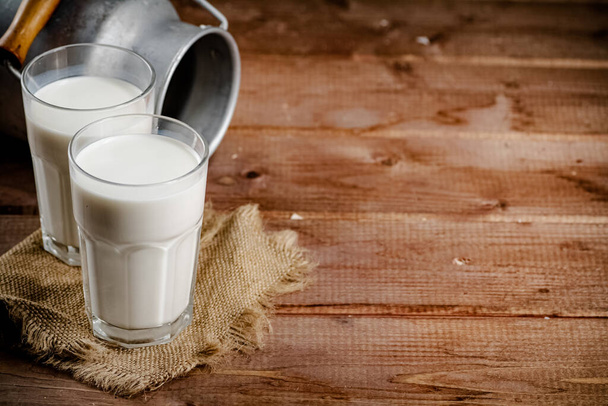 A glass of homemade village milk. On a wooden background. High quality photo - Φωτογραφία, εικόνα