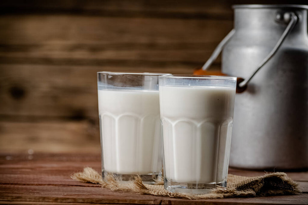 A glass of homemade village milk. On a wooden background. High quality photo - Foto, imagen