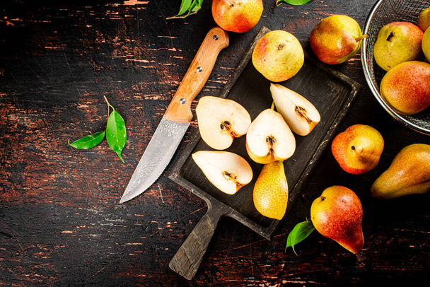 Sliced fresh pear on a cutting board. Against a dark background. High quality photo - Photo, Image