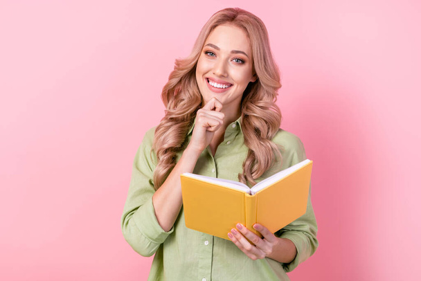 Photo of cheerful intelligent woman dressed green shirt arm chin reading story isolated pink color background. - Photo, Image