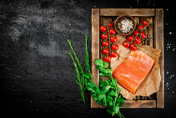 Salted salmon with parsley and tomatoes on a wooden tray. On a black background. High quality photo - Фото, зображення