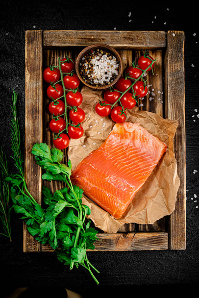 Salted salmon with parsley and tomatoes on a wooden tray. On a black background. High quality photo - Фото, зображення