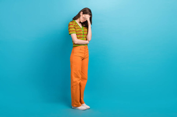 Full size photo of upset disappointed woman with wavy hairdo dressed colorful cardigan arm cover eyes isolated on blue color background. - 写真・画像