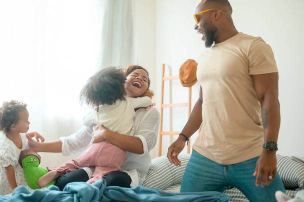 Happy African American Parents with  little daughters playing on the bed in bedroom at home, happy family concept - Φωτογραφία, εικόνα