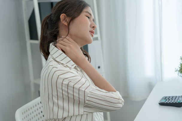 sindromi da ufficio, donna che massaggia il dolore al collo dovuto al lavoro e utilizza un computer, composito digitale di una colonna vertebrale concentrata di dolore al collo e dolore alla spalla sintomi, lesioni, assistenza sanitaria, medico, miosite - Foto, immagini